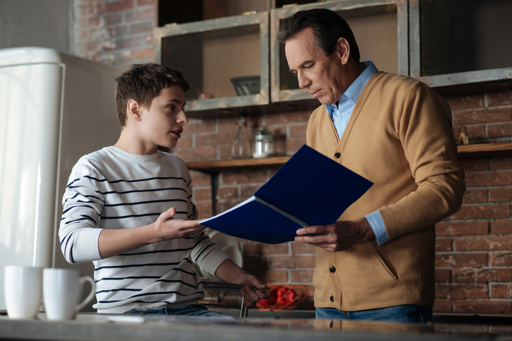 Dad looking at son's notebook