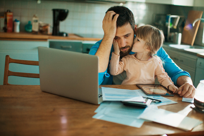 Dad with paperwork, daughter sitting on his lap