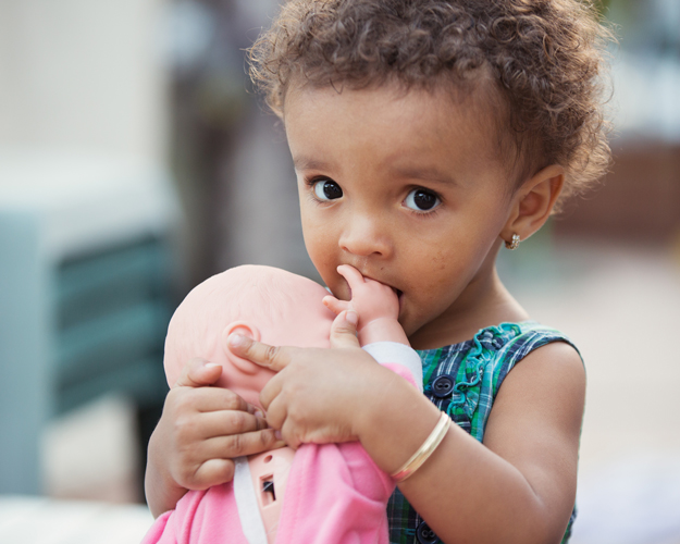 Scared child holding a doll
