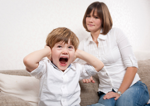 Child screaming and covering his ears