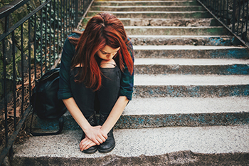 Sad teen sitting on stairs