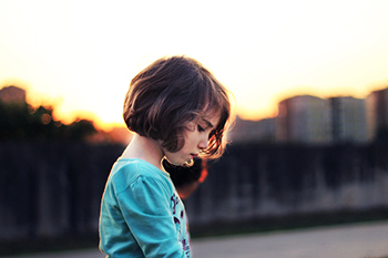 Child looking down, sad