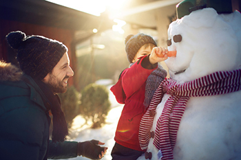 Father and child building a snowman