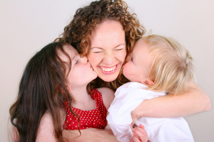 Daughters kissing Mom on the cheek