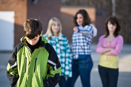 Sad boy walking away from group of bullies