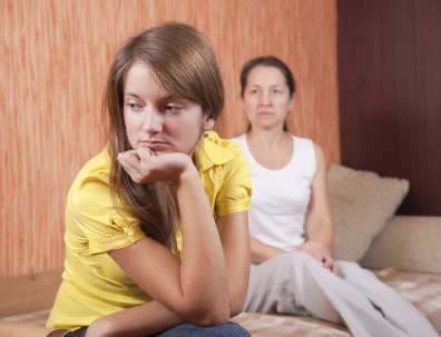 Upset teen with mom in the background