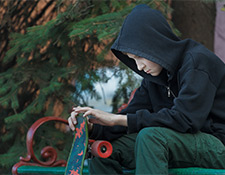 Upset boy holding skateboard
