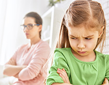 Young girl with arms crossed, looking angry