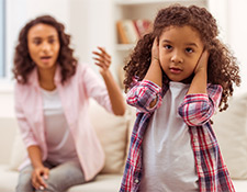 Daughter with hands over her ears, ignoring parent